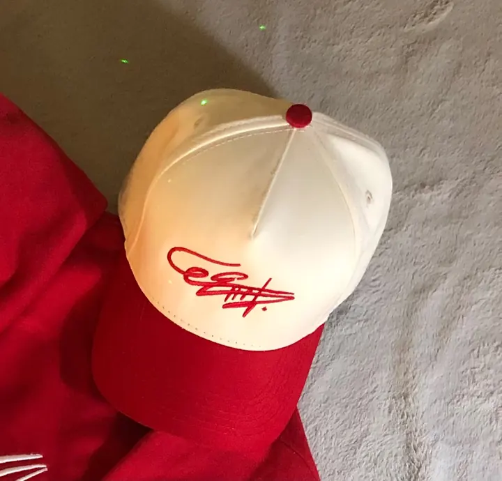 Gorra crema con visera roja y la firma de Eros bordada